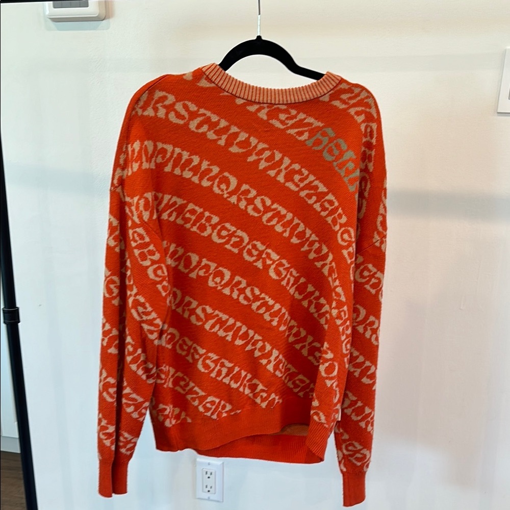 Vibrant Orange Crewneck Sweater with Text Pattern